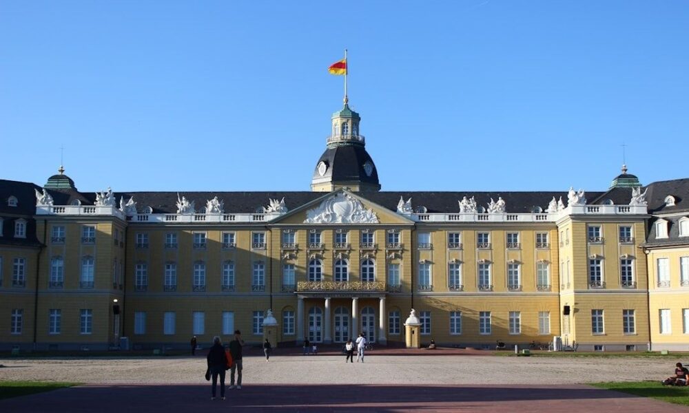 Historisches Karlsruher Schloss mit deutscher Flagge vor blauem Himmel
