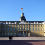 Historisches Karlsruher Schloss mit deutscher Flagge vor blauem Himmel