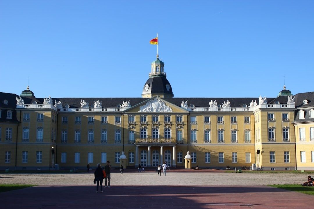 Historisches Karlsruher Schloss mit deutscher Flagge vor blauem Himmel